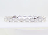 Sterling silver semi mount tennis bracelet setting with oval cabochon halo and white topaz accents.